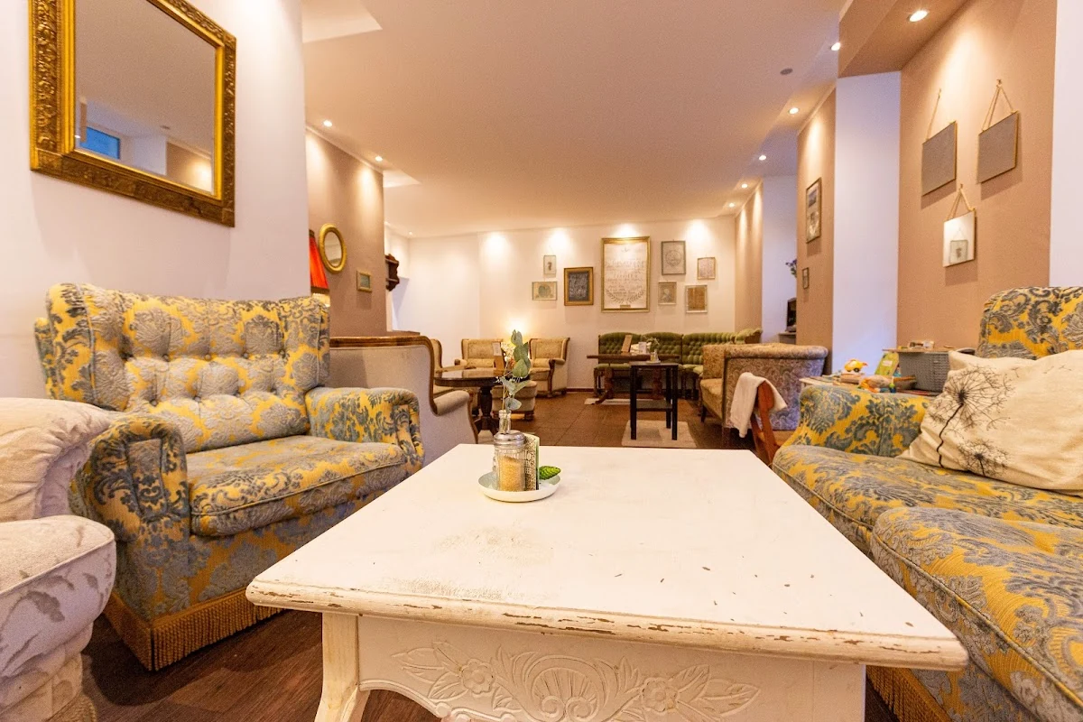 Das Wohnzimmer im Café wunderbar mit Sesseln, Sofas und einem großen Tisch